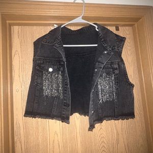 Cropped black sleeveless jacket with sparkle fringe